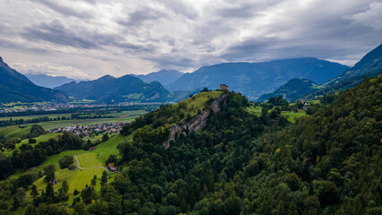 Beautiful rock with a forest an a cloudy day with mountains in the background - Drone Perspective Landscape Photography