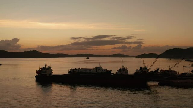 Sunset over the bay with the seaport and ships on the island of Siargao, Philippines. Dapa Ferry Terminal.