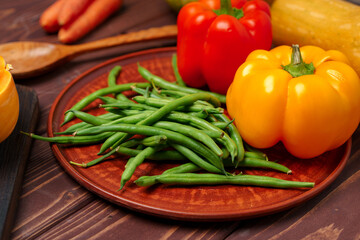 Green beans in clay plate with vegetables