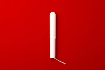 Female tampon on red background top view