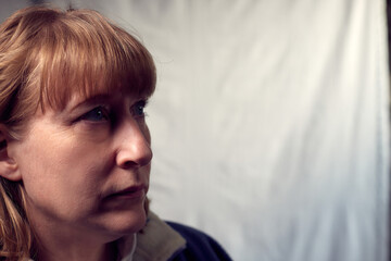 Portrait of a middle-aged woman on a white background. Unprofessional female model clumsily ineptly posing in the Studio.