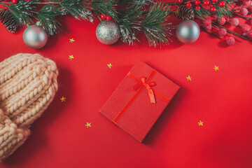 Christmas background with gift boxes, rose hat and decorations on red. Preparation for holidays. Top view.