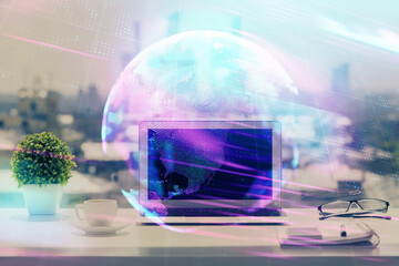 Computer on desktop in office with technology theme hologram. Double exposure. Tech concept.