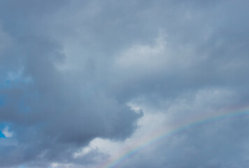 Naklejka na ściany i meble Clouds with a rainbow after the rain