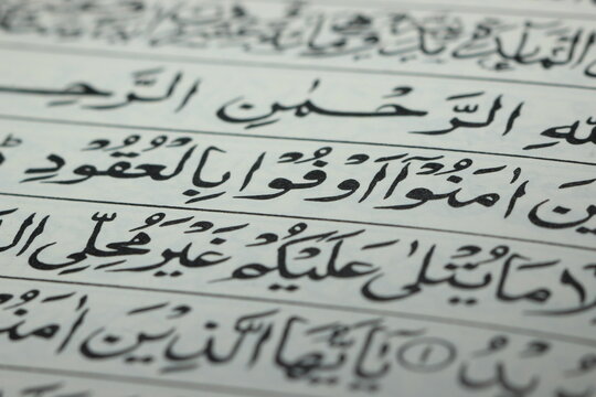 Closeup shot of Islamic Book Quran with golden arabic calligraphy