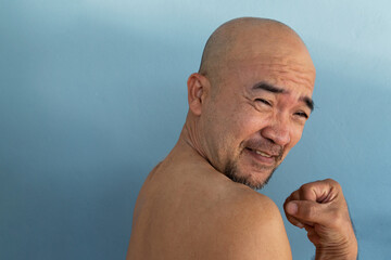 side portrait 40s happy smiling beard bald Japanese topless man on blue background