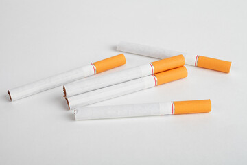 Cigarette with an orange filter on a white background.
