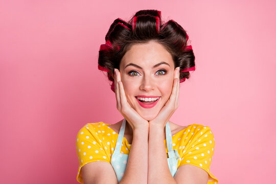 Close-up portrait of her she nice-looking delighted cheerful brown-haired housewife wearing rollers touching cheeks isolated on pink color background
