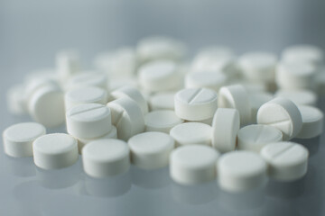 Fototapeta na wymiar White pills on glass table