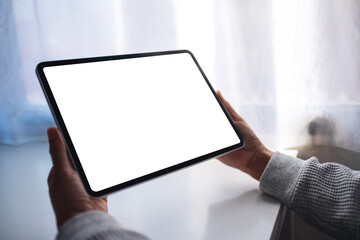 Mockup image of a woman holding digital tablet with blank white desktop screen