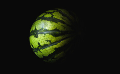 Whole fresh watermelon fruit, shaded on a black background.