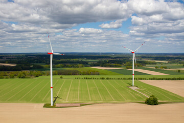 wind turbine, wind farm on a sunny cloudy day shot from eye level, hub height with agricultural landscape below