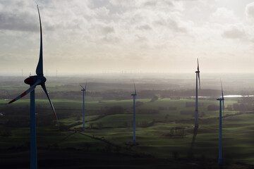 wind turbine, wind farm on a sunny misty morning shot from eye level, hub height with agricultural...