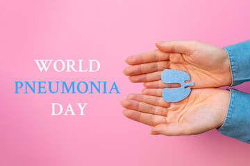 World pneumonia day. Woman's hands hold the cut-out silhouette of the lungs. Flat lay. Pink background. Text