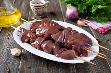 Pieces of raw pork liver on wooden skewers for cooking barbecue. Diet dish. Asian cuisine.
