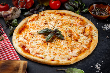  Italian pizza margarita and ingredients for its preparation on the table close-up