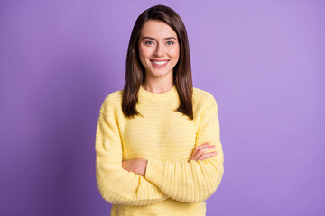Obraz premium Photo portrait of young happy pretty girl smiling with crossed hands wearing yellow clothes isolated on vibrant violet background