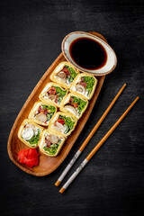  Japanese rolls with chicken and cream cheese on a black background top view vertical photo