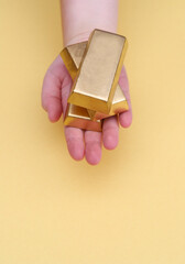 Hand holding gold bars.