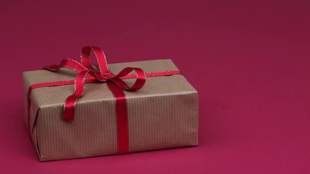 Christmas gift jumping on red background. Hidden surprise inside the box concept. 4K stop motion animation.