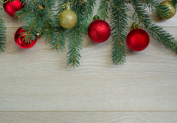 Fototapeta na wymiar Christmas composition of fir branches and red, gold balls on wooden boards