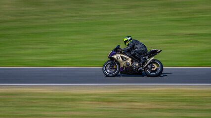 Fototapeta premium A panning shot of a racing bike cornering on a track.