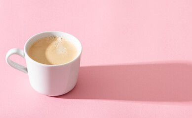 cup of coffee on a pastel pink background, photography with contrast shadow