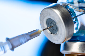 Vaccine bottle with a syringe taking the vaccine from it