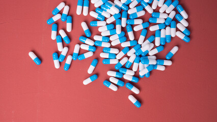white and blue pills on red background