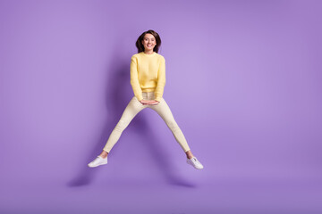 Fototapeta na wymiar Photo portrait full body view of girl jumping up with spread legs hands down isolated on bright purple colored background