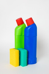 Cleaning agent or disinfectant in green and blue bottles with  sponges on a white background