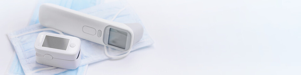 Portable Pulse Oximeter, infrared medical thermometer on Background face mask to monitor oxygen...