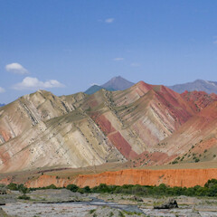 Landscape view of colorful red and orange rock strata in the Alay or Alai mountain range along the...