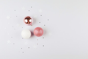 Silver confetti, pink christmas balls on background. Flat lay, copy space, holiday background.
