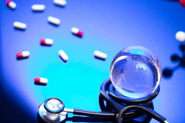 Healthcare concept. Stethoscope and medicines. Blue table and background.
