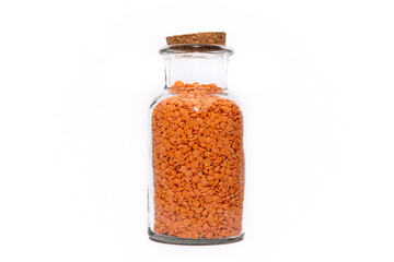 A Jar of Split Lentils isolated on a white background, bright orange legume dried and stored. Healthy food choice.
