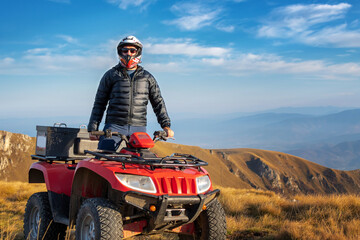 A man on a quad bike in the mountains. 