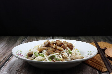 Rice noodle salad mixed with roasted pork, sliced string bean and fresh bean sprouts seasoning with pickled fish sauce on the plate. Famous traditional appetizer menu in Asia restaurant.