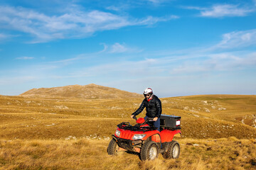 A man on a quad bike in the mountains. 
