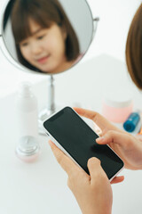 Beautiful young asian thai black short hair woman using smartphone in restroom.