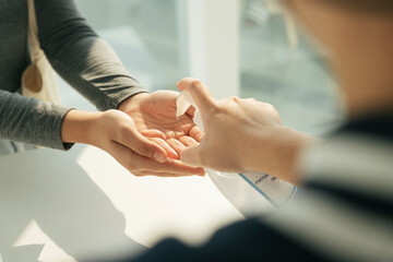 Obraz premium People applying using putting alcohol gel on hands.