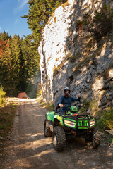 A man on a quad bike in the mountains.