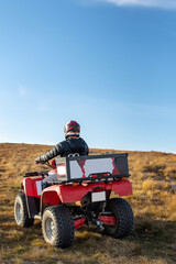 A man on a quad bike in the mountains.