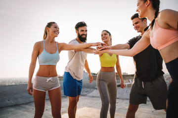 Group of cheerful fit fitness team exercising together outdoor