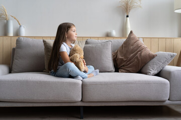 Obraz premium Positive smiling school girl lying on a couch.