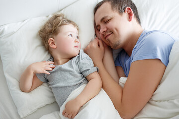 top view of happy father and cute little daughter waking up at home