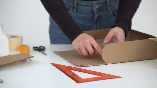 A man cuts strips of scotch&nbsp;tape and sticks it