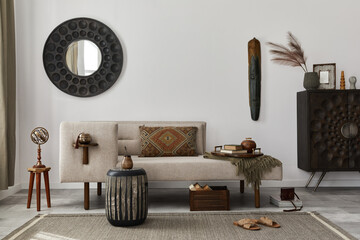Interior design of ethnic living room with modern commode, round mirror, decoration, furniture and...