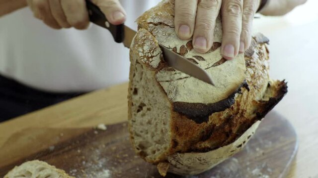 Close up slow motion cutting sourdough bread loaf, crumb