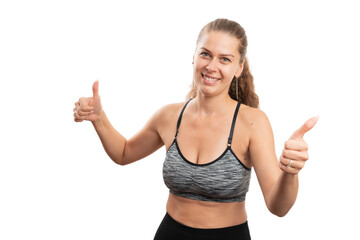 Fototapeta na wymiar Friendly female model in gym attire showing double like gesture